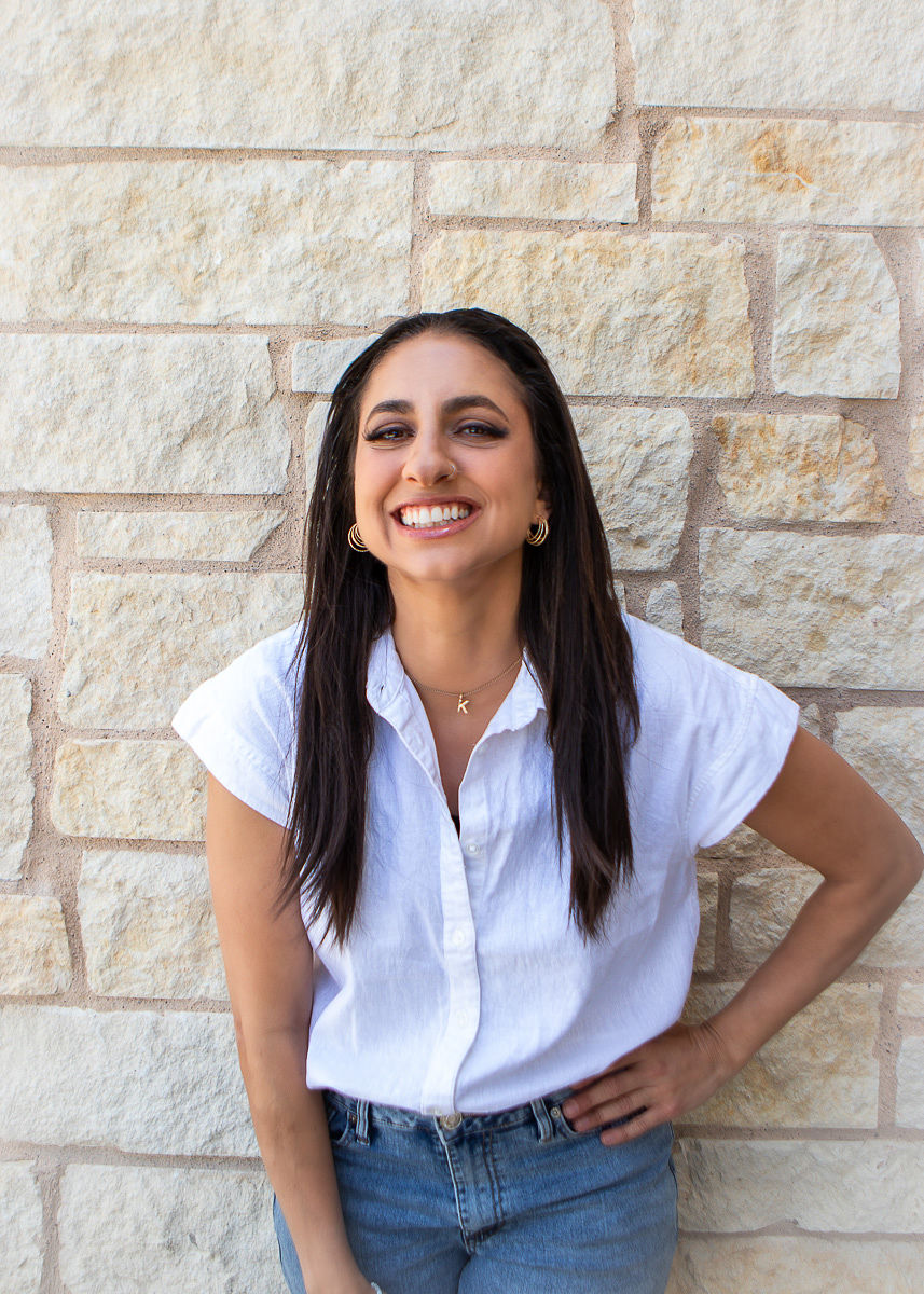 Karen Posner smiling against a stone wall